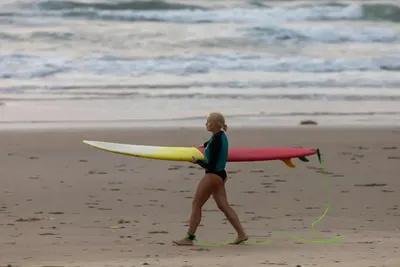 Walking out with a longboard on a Mui Ne beach