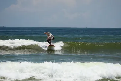 K1 student riding a wave, surf lesson in Mui Ne