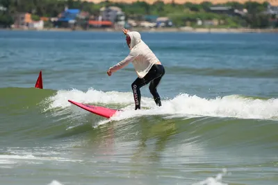 Surfing in Mui Ne: student riding past the buoys