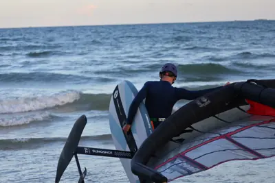Walking out with a Cabrinha foil board and a wing