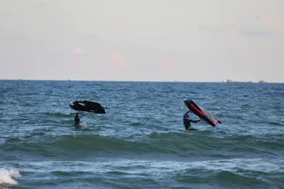 Two students lifting their wings while kneeling on the boards